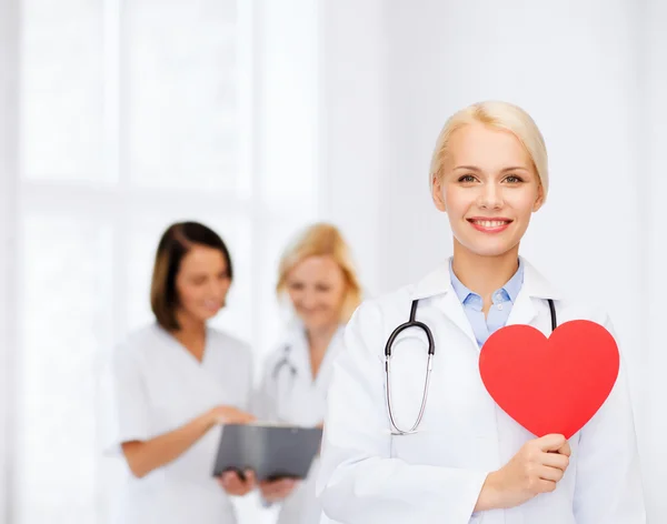 Femme médecin souriante avec cœur et stéthoscope — Photo