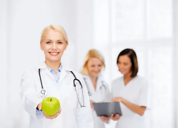 Smiling female doctor with green apple — Stock Photo, Image