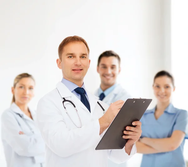 Sonriente médico varón con portapapeles y estetoscopio — Foto de Stock