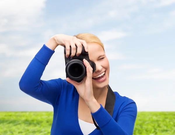 Mulher sorridente tirando foto com câmera digital — Fotografia de Stock