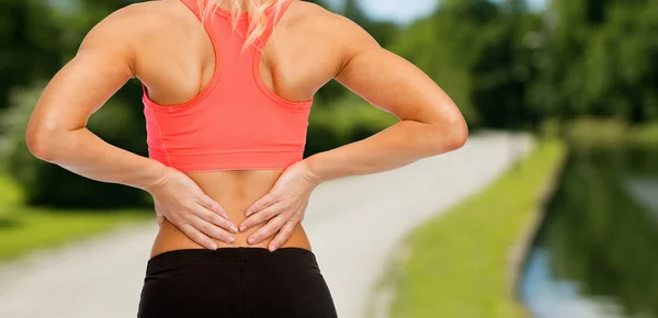 Close up of sporty woman touching her back — Stock Photo, Image