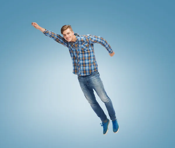 Smiling young man jumping in air — Stock Photo, Image