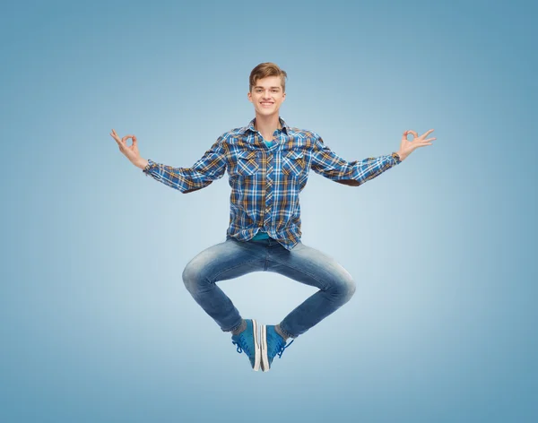 Lächelnder junger Mann springt in die Luft — Stockfoto