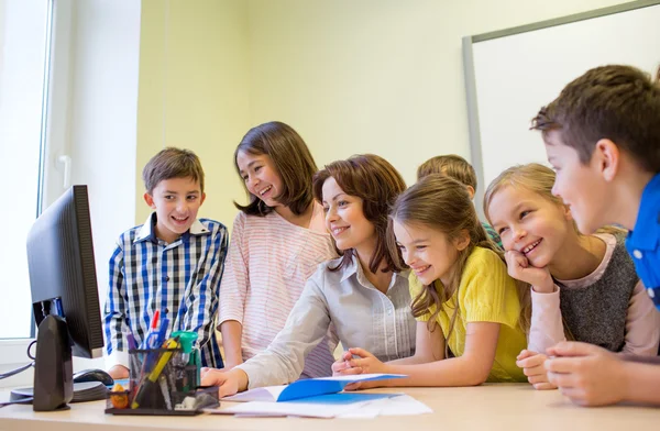 Groupe d'enfants avec professeur et ordinateur à l'école — Photo