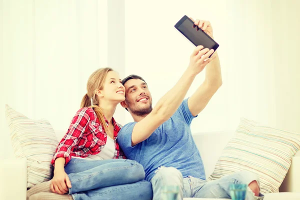 Casal sorridente com computador tablet pc em casa — Fotografia de Stock