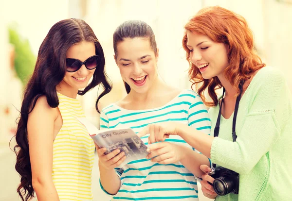 Ragazze adolescenti sorridenti con guida della città e macchina fotografica — Foto Stock