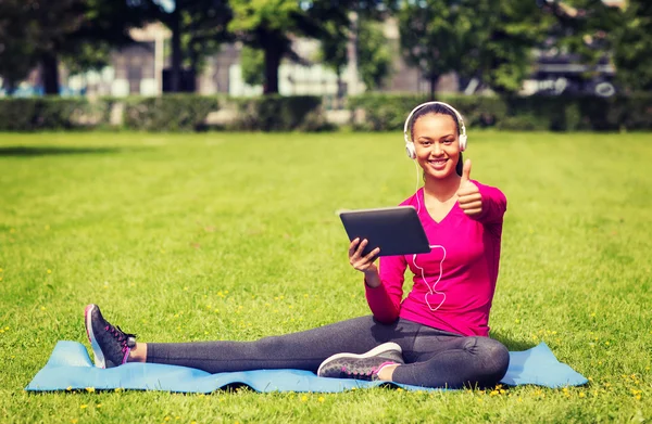 Lachende vrouw met tablet pc buitenshuis — Stockfoto