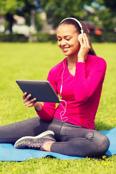 Lachende vrouw met tablet pc buitenshuis — Stockfoto