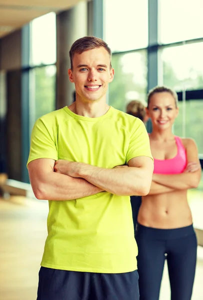 Glimlachende man en vrouw in de sportschool — Stockfoto
