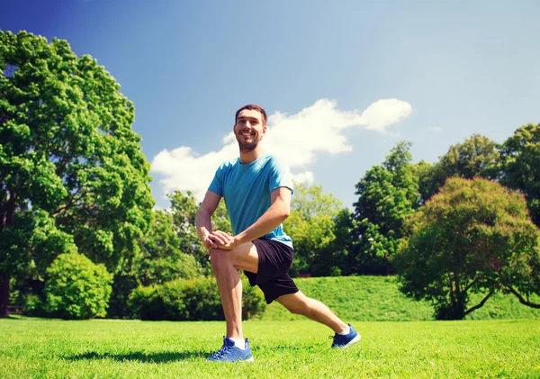 Smiling man stretching outdoors — Stock Photo, Image