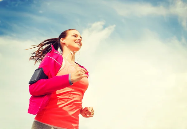 Smiling young woman running outdoors — Stock Photo, Image