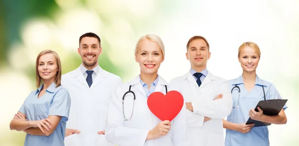 Grupo de médicos sonrientes con forma de corazón rojo — Foto de Stock