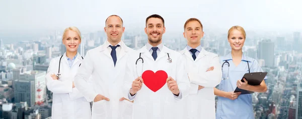 Grupo de médicos sonrientes con forma de corazón rojo —  Fotos de Stock