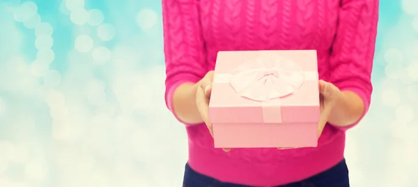 Gros plan de la femme en pull rose tenant boîte cadeau Images De Stock Libres De Droits