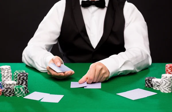 Negociante holdem com cartas de jogo e fichas de casino — Fotografia de Stock