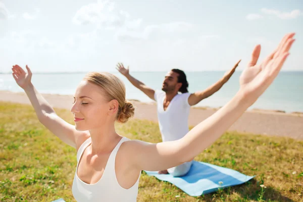 Çift gülümseyen açık havada yapım yoga egzersizleri — Stok fotoğraf