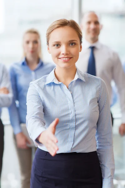 Glimlachende zakenvrouw handdruk maken in office — Stockfoto