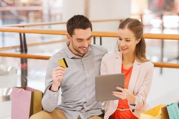 Casal com tablet pc e cartão de crédito no shopping — Fotografia de Stock