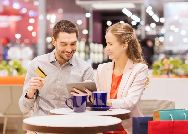 Casal com tablet pc e cartão de crédito no shopping — Fotografia de Stock