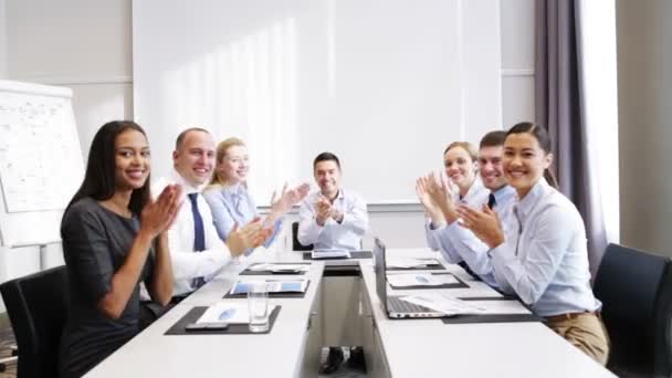 Sonrientes personas de negocios reunidas en la oficina — Vídeos de Stock