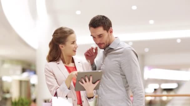 Casal com tablet pc e sacos de compras no shopping — Vídeo de Stock