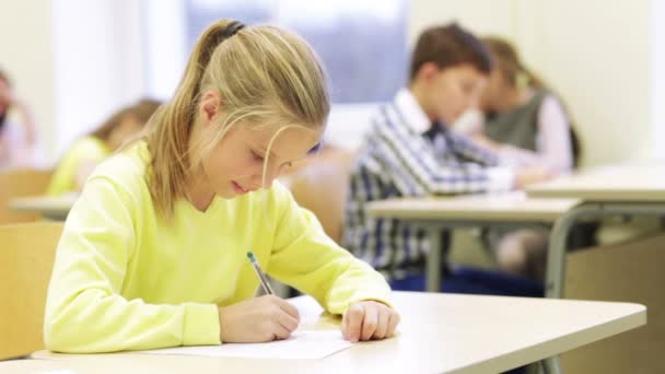 Group of school kids writing test in classroom — Stock Video