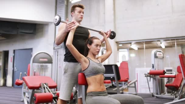 Man en vrouw met lange halter flexing spieren in de sportschool — Stockvideo