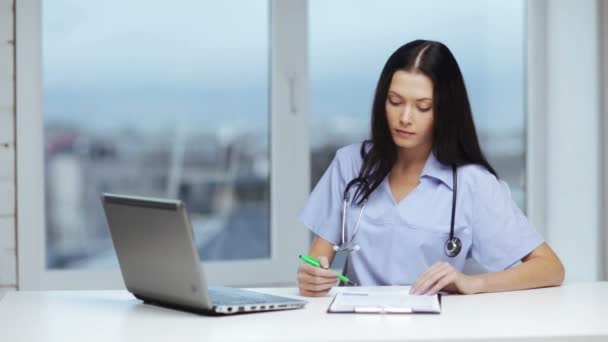 Doctor or nurse with laptop pc writing prescription — Stock Video