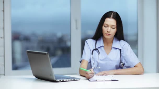 Doctor or nurse with laptop pc writing prescription — Stock Video