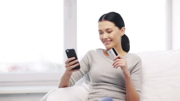 Mulher sorridente com smartphone e cartão de crédito — Vídeo de Stock