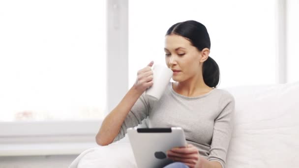 Mujer sonriente con tablet PC y taza — Vídeos de Stock