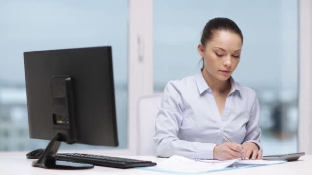 Mujer con computadora, papeles y calculadora — Vídeo de stock