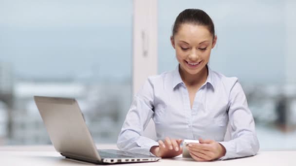 Mulher de negócios sorridente com laptop e smartphone — Vídeo de Stock