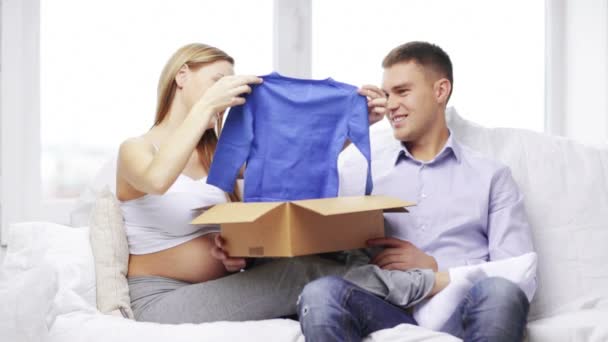 Familia feliz mirando ropa de bebé — Vídeos de Stock