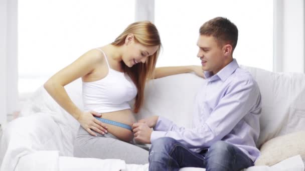 Šťastný manžel měření pasu těhotné ženy — Stock video