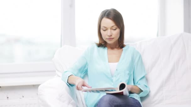 Femme calme lecture magazine et assis sur le canapé — Video