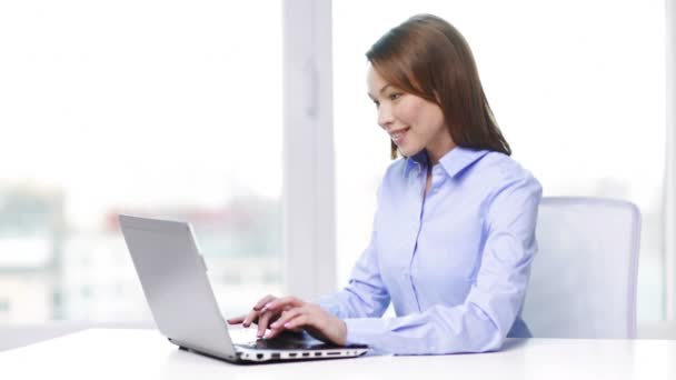 Smiling businesswoman with laptop in office — Stock Video