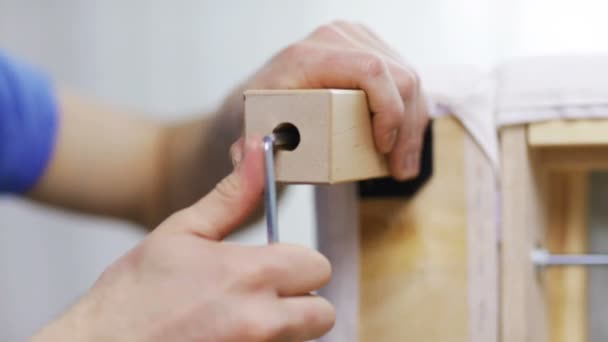 Close up of male hands assemblying legs to sofa — Stock Video