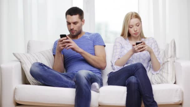 Pareja concentrada con smartphones en casa — Vídeos de Stock