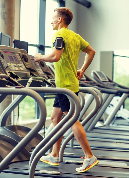 Mann mit Smartphone trainiert auf Laufband im Fitnessstudio — Stockfoto