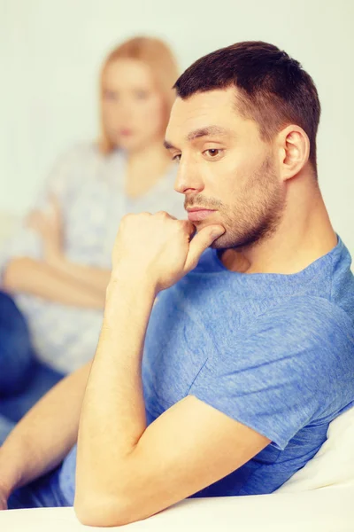 Upset young man with man on the back at home — Stock Photo, Image