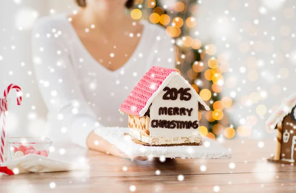 Kadın gösteren gingerbread evi yakın çekim — Stok fotoğraf