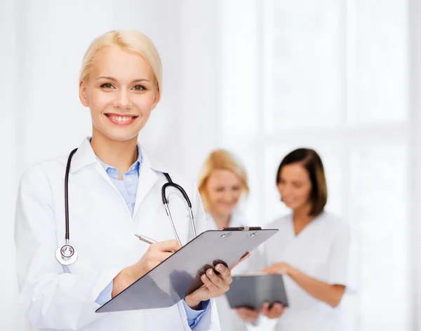 Médica sorridente com prancheta — Fotografia de Stock