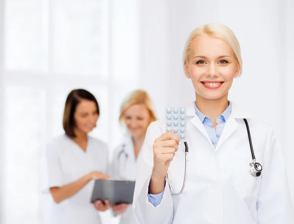 Uśmiechnięta kobieta lekarz z pigułki — Zdjęcie stockowe