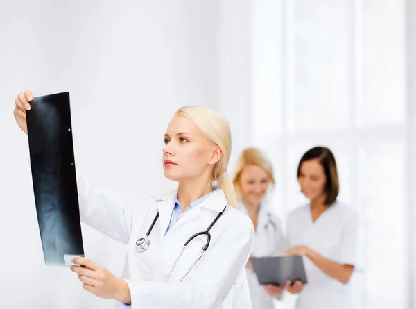 Médico femenino serio mirando rayos X — Foto de Stock