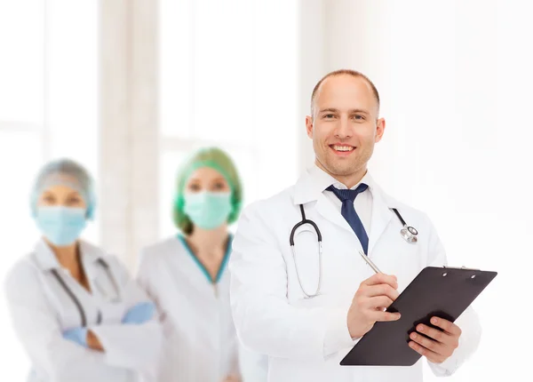 Sorridente médico masculino com prancheta e estetoscópio — Fotografia de Stock