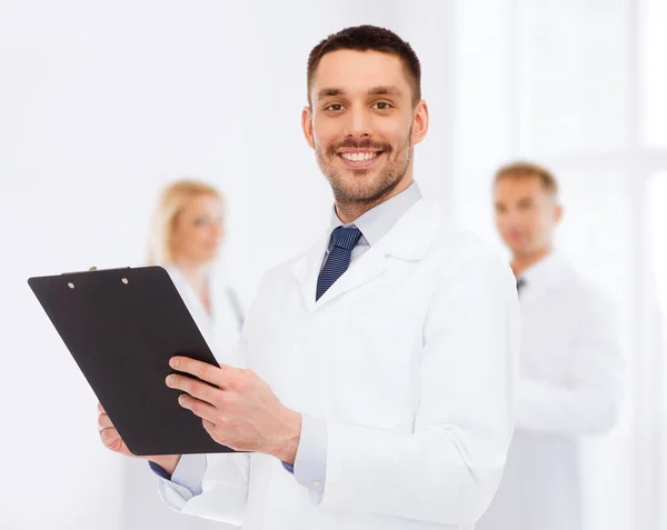 Docteur mâle souriant avec presse-papiers — Photo