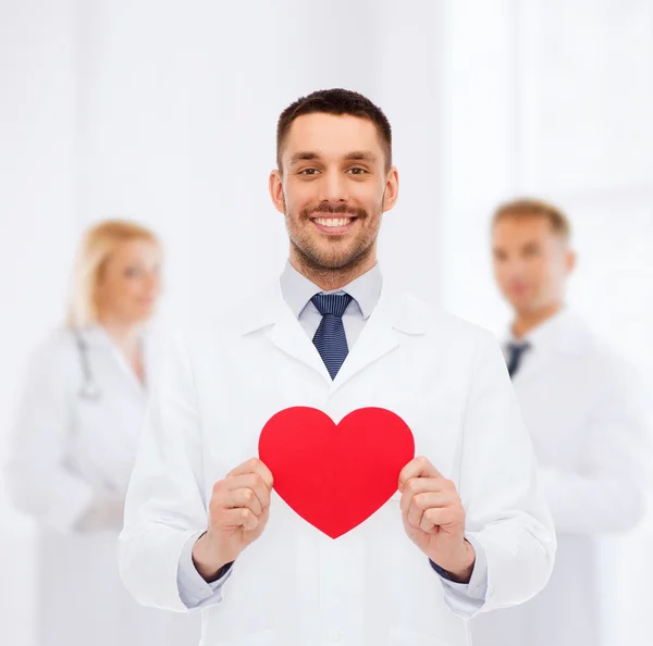 Sorridente médico masculino com coração vermelho — Fotografia de Stock