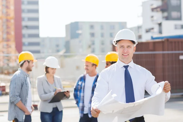 Grupo de construtores com tablet pc e planta — Fotografia de Stock