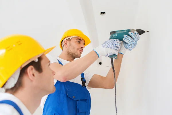 Grupo de constructores con taladro en interiores — Foto de Stock